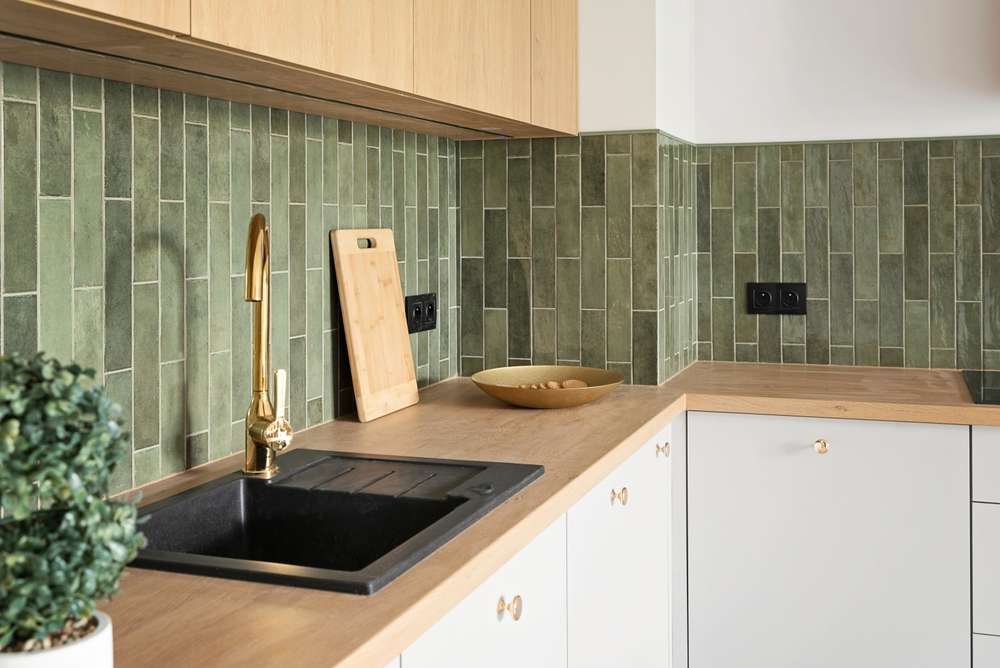 Centennial kitchen remodeled by Meza Tile and Stone with a sage tile backsplash, wood countertop, and oak cabinetry