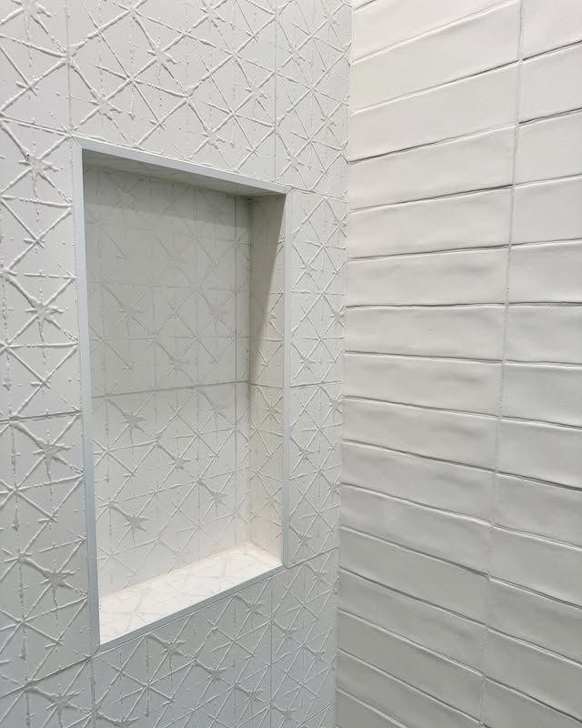 White textured tile shower with recessed niche and wall tile